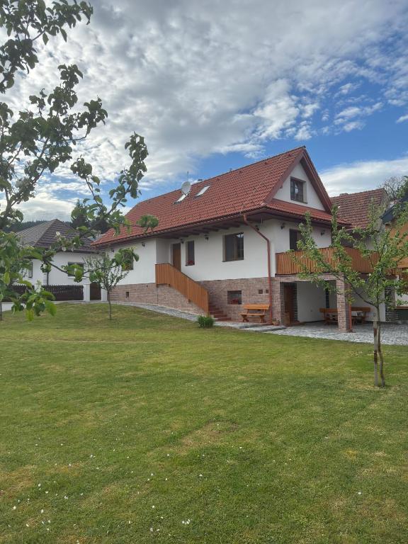 a large white house with a grass yard at Chalúpka Barborka in Lúčky