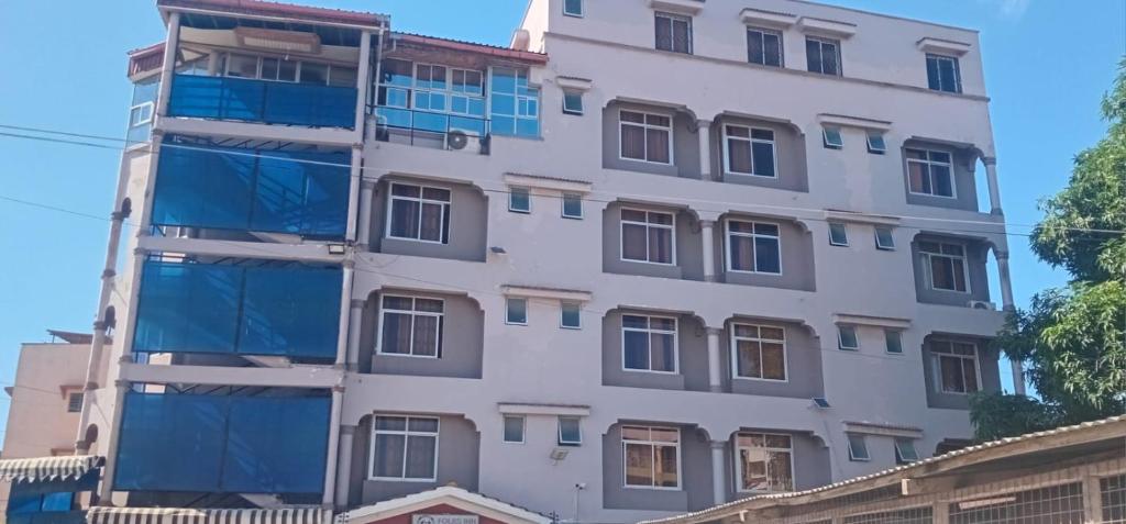 a tall white building with many windows at The Folks Inn in Mombasa