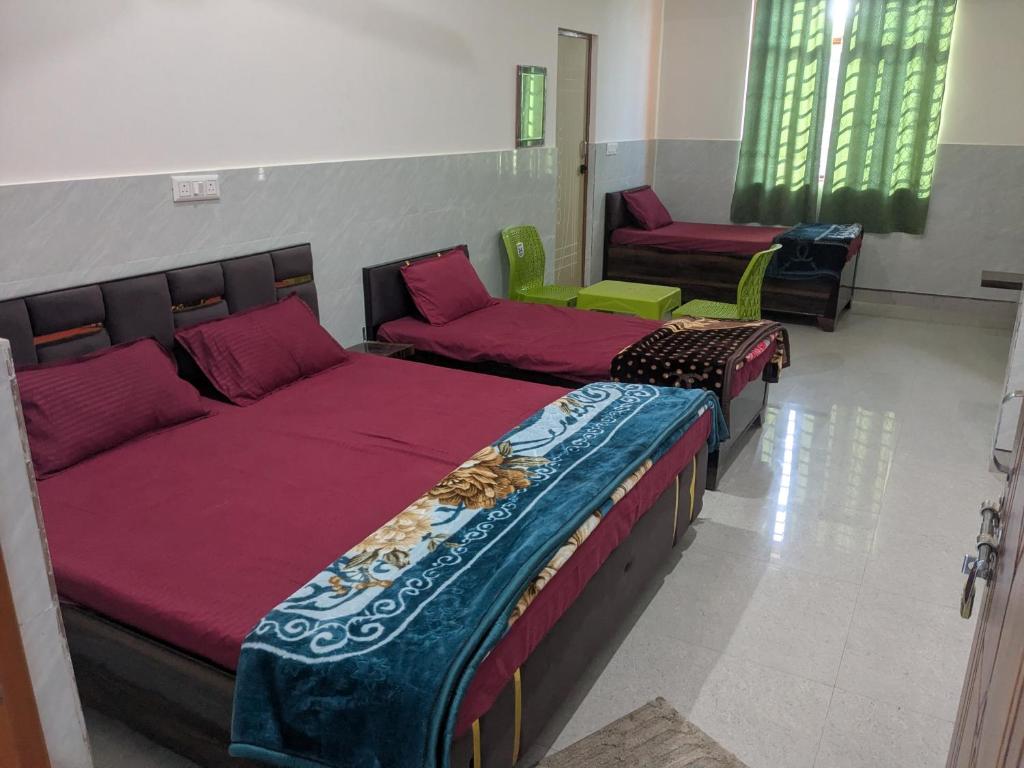 a room with three beds and a couch at Hotel Badri Palace in Rishīkesh