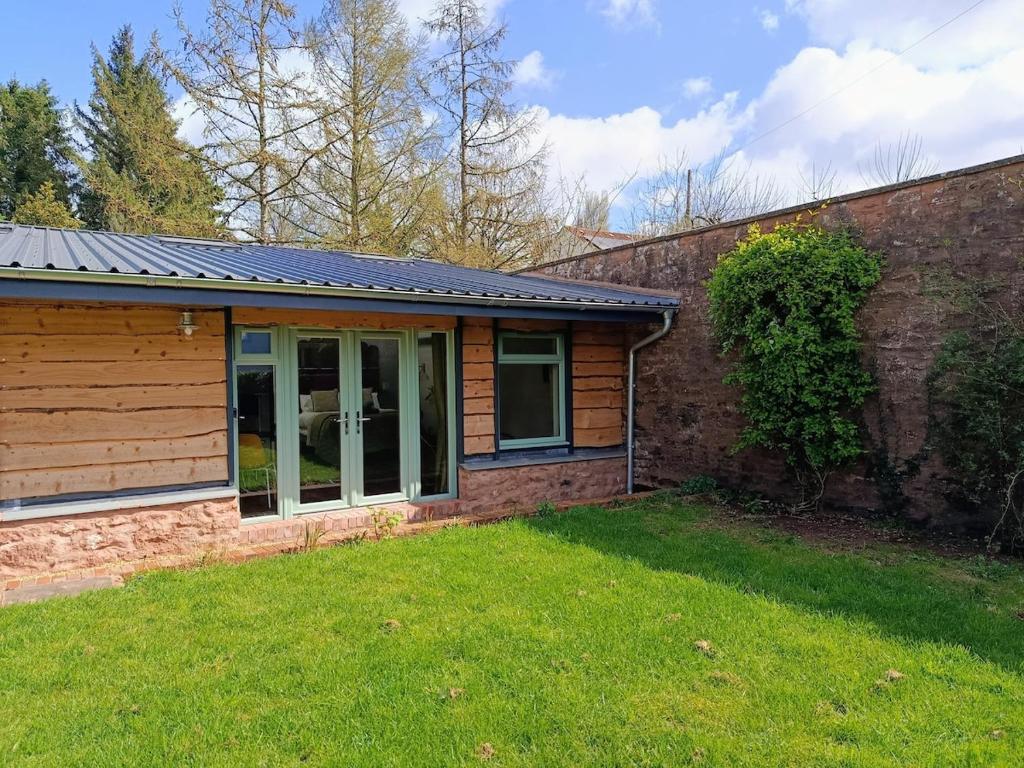 a house with a solar roof on top of a yard at Lodge Two The Old Gasworks in Milverton