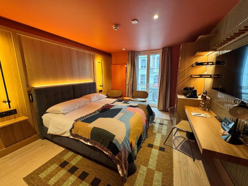 a hotel room with a bed and a desk and a desk at Hotel Alpina Luzern in Lucerne