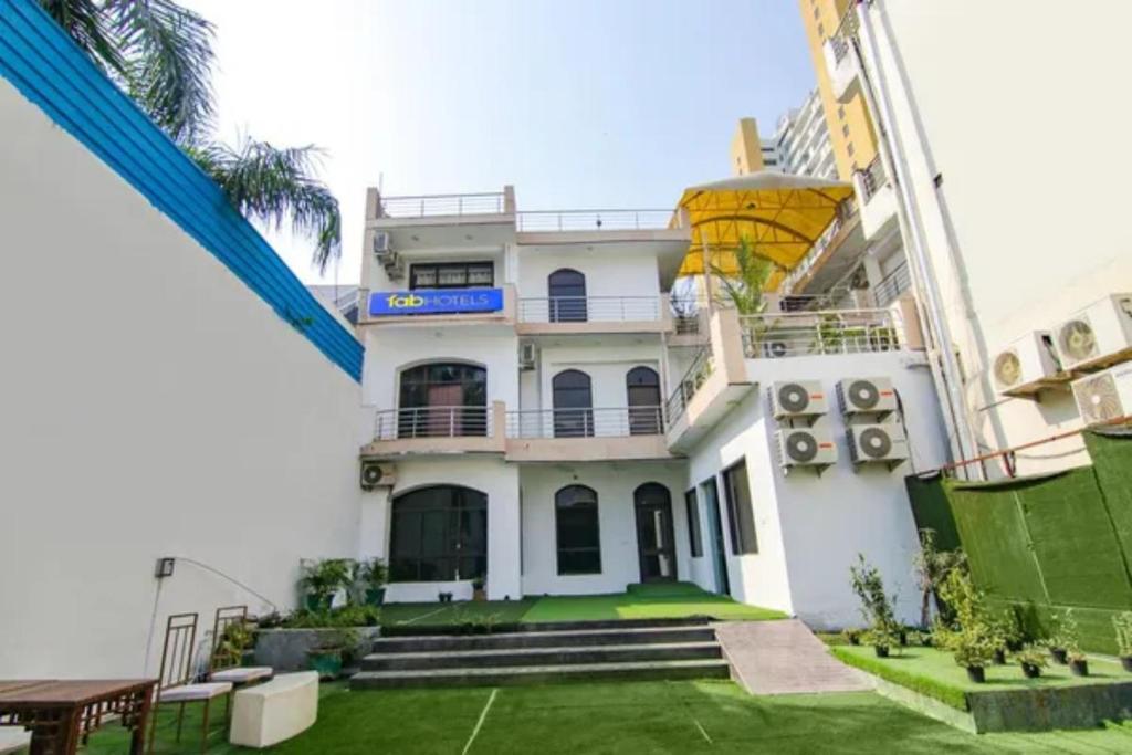 a large white building with a balcony at FabHotel Signature Luxe Inn - Chhattarpur in New Delhi