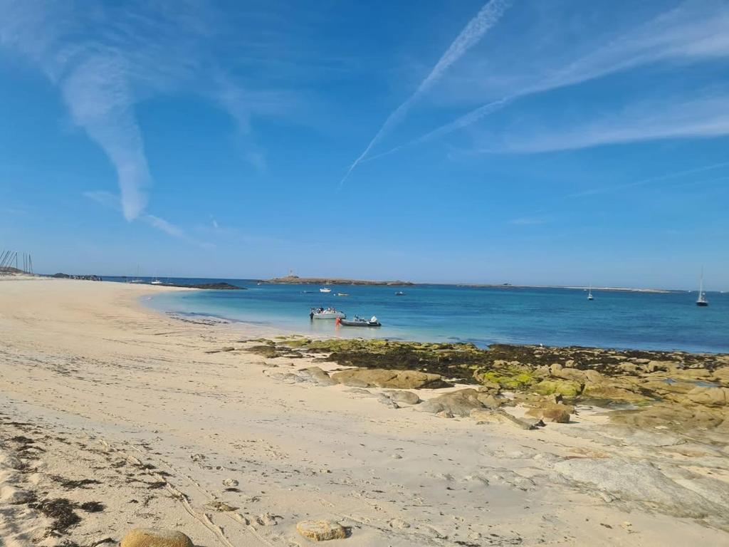 a view of a beach with boats in the water at Maison de pêcheurs in Trégunc
