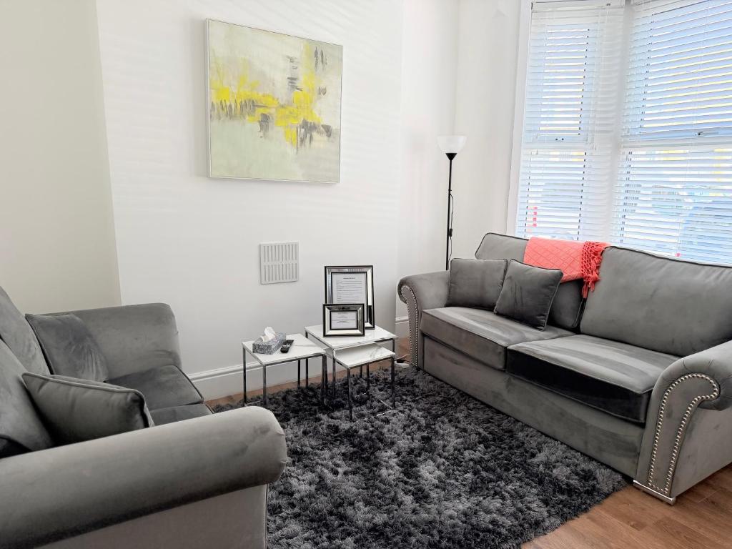 a living room with two couches and a table at The Cosy Nest Modern - 3BR House - Sleeps 7 - Near City Centre - STARLINK Wi-fi in Liverpool