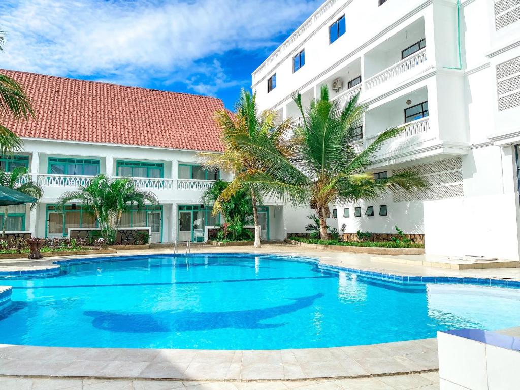 a swimming pool in front of a building at The Safiya Hotel Apartments in Ukunda