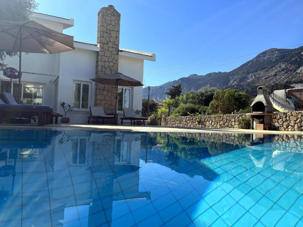 a swimming pool in front of a villa at Villa Zeytin - Private Pool Villa in Vasilia