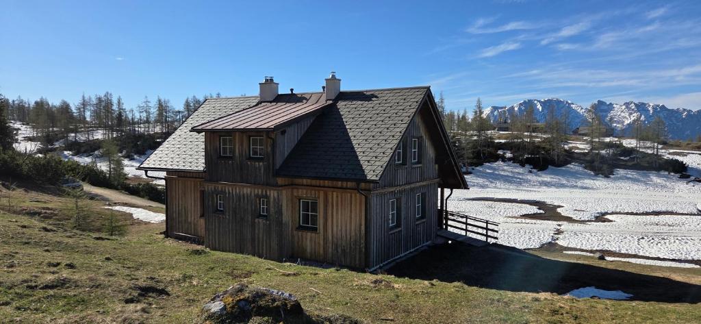 a house on top of a hill with snow at Gindlhütte in Tauplitzalm