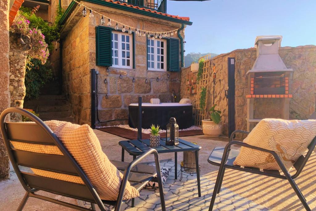 a patio with two chairs and a table with a stove at Regouro - an Hidden Gem in Douro Valley in Boassas