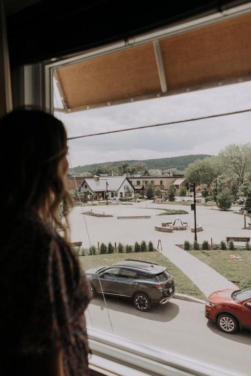 a woman looking out of a window at a car at Downtown - FREE shuttle to Ski Resort - Ice Rink in Mont-Tremblant