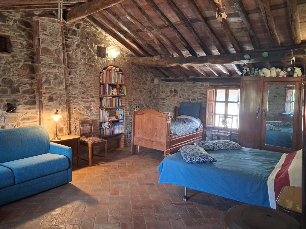 a bedroom with a bed and a couch and a chair at Attic with balcony at Locanda del Capo in Capannori