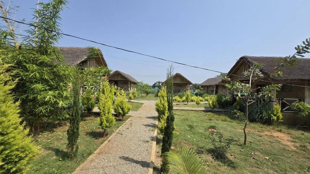 a path through a garden with houses at Ecospace Kabini in Kabini River