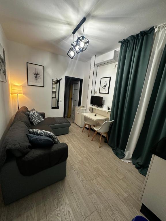 a living room with green curtains and a couch at Appartamento Antares Piazza Fontana in Lignano Sabbiadoro