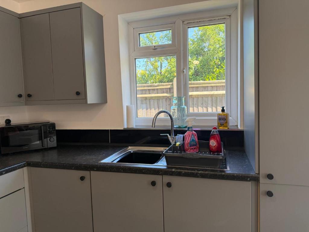 a kitchen counter with a sink and a window at Gatwick 2 Bed Apartments Free Parking in Horley