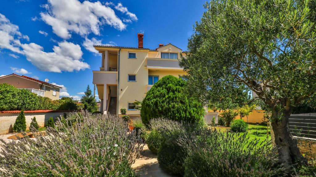 a house in a garden with trees and bushes at Sonnengarten floor 2 in Marčana
