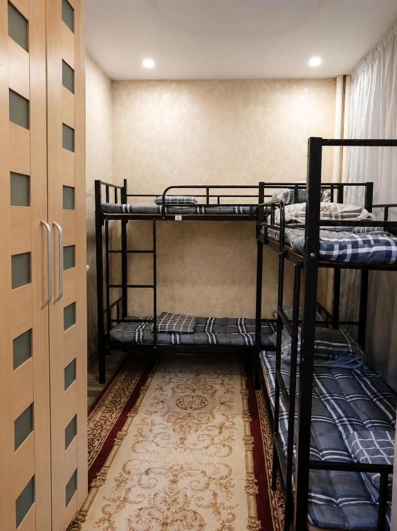 two bunk beds in a room with a carpet at Ayvan Eco Hostel in Tashkent