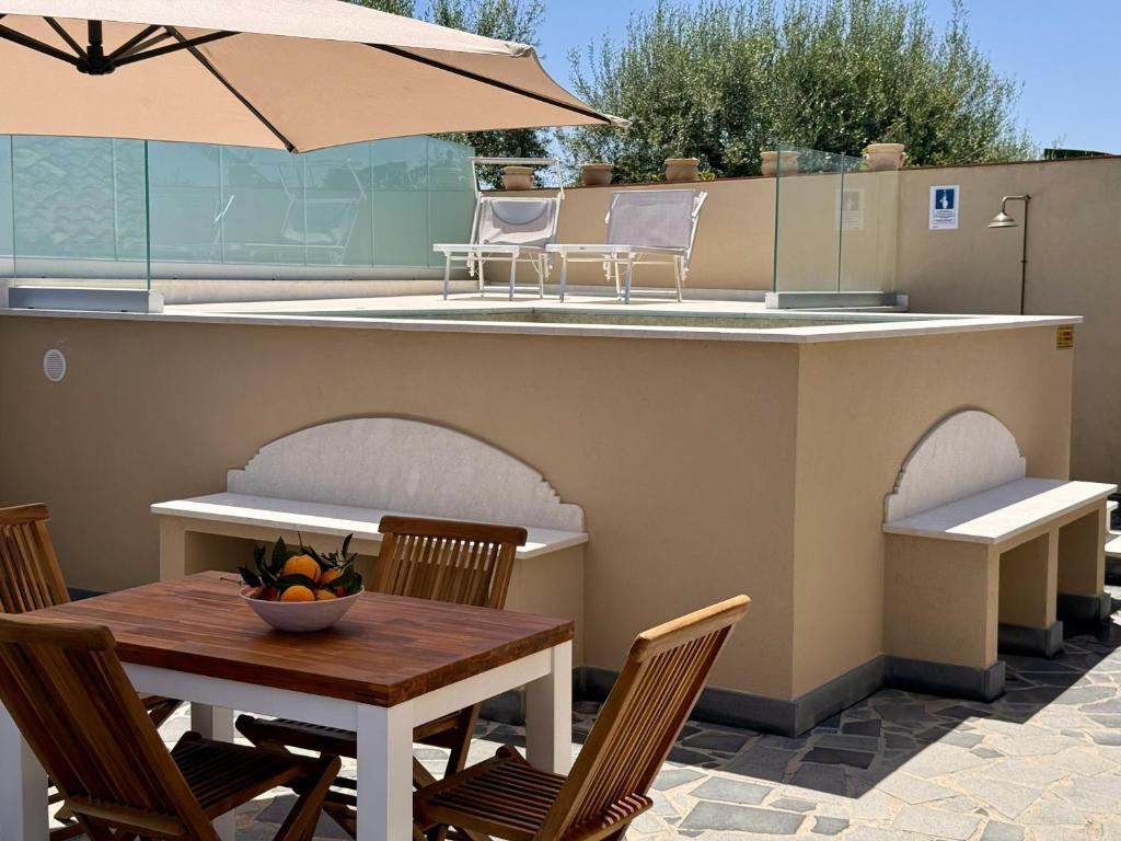 a table and chairs and an umbrella on a patio at Casa Sautu-fau in Santa Venerina