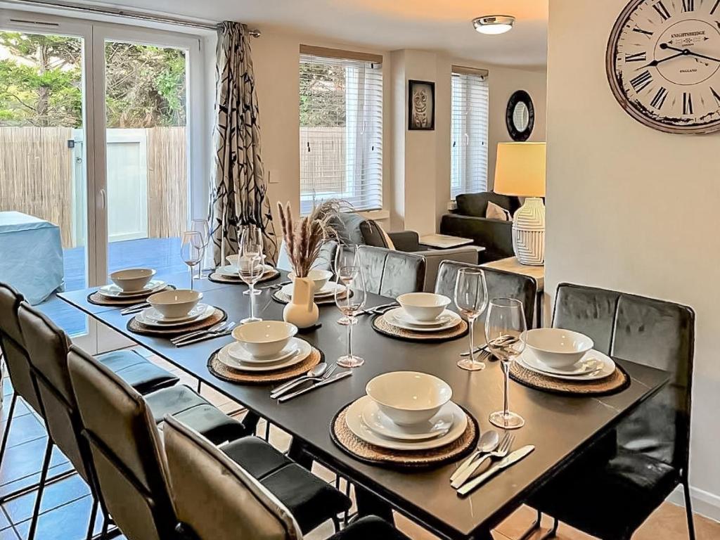 a dining room table with chairs and a clock on the wall at Summerleaze House in Bude