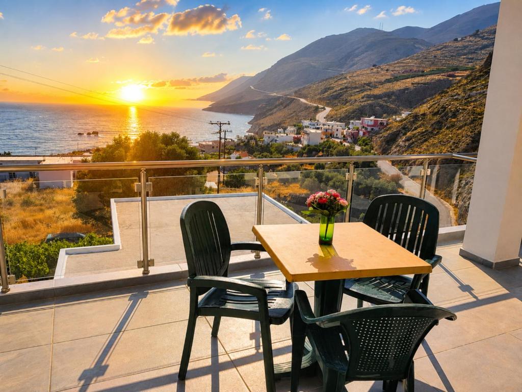 a table and chairs on a balcony with a view of the ocean at 4Seasons Sfakia in Hora Sfakion