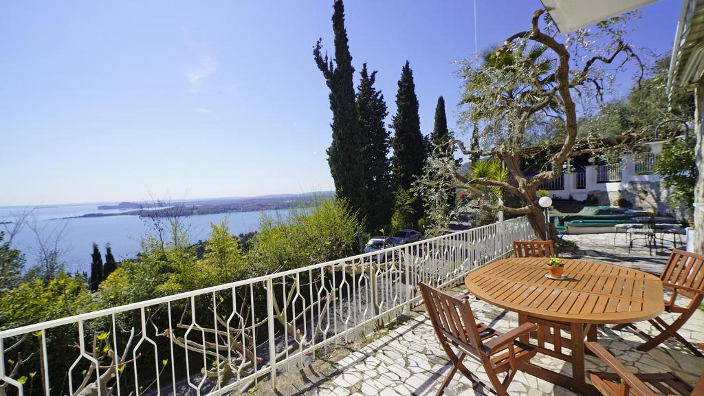 a table and chairs on a balcony with a view of the water at Villa Samanta in Gardone Riviera
