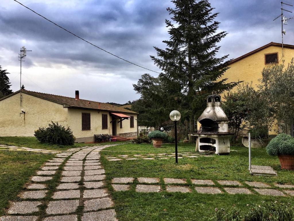 a garden with a brick path leading to a house at Il Bettarello in Roccastrada