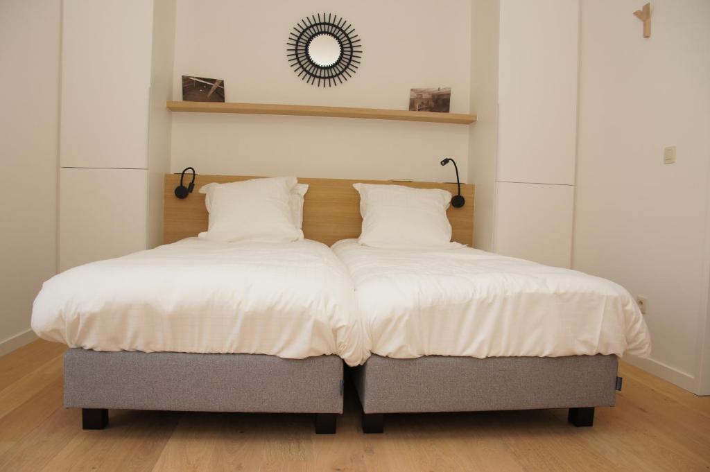 a bed with two pillows on it in a room at Vakantiewoning Hof ter Heidje in Maarkedal