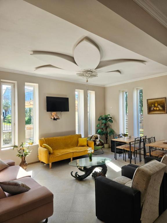 a living room with a yellow couch and a table at Guesthouse Maka in Ureki
