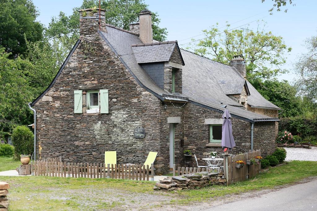 an old stone house with a fence in front of it at Gîte La P'tite Longère in Saint-Jacut-les-Pins