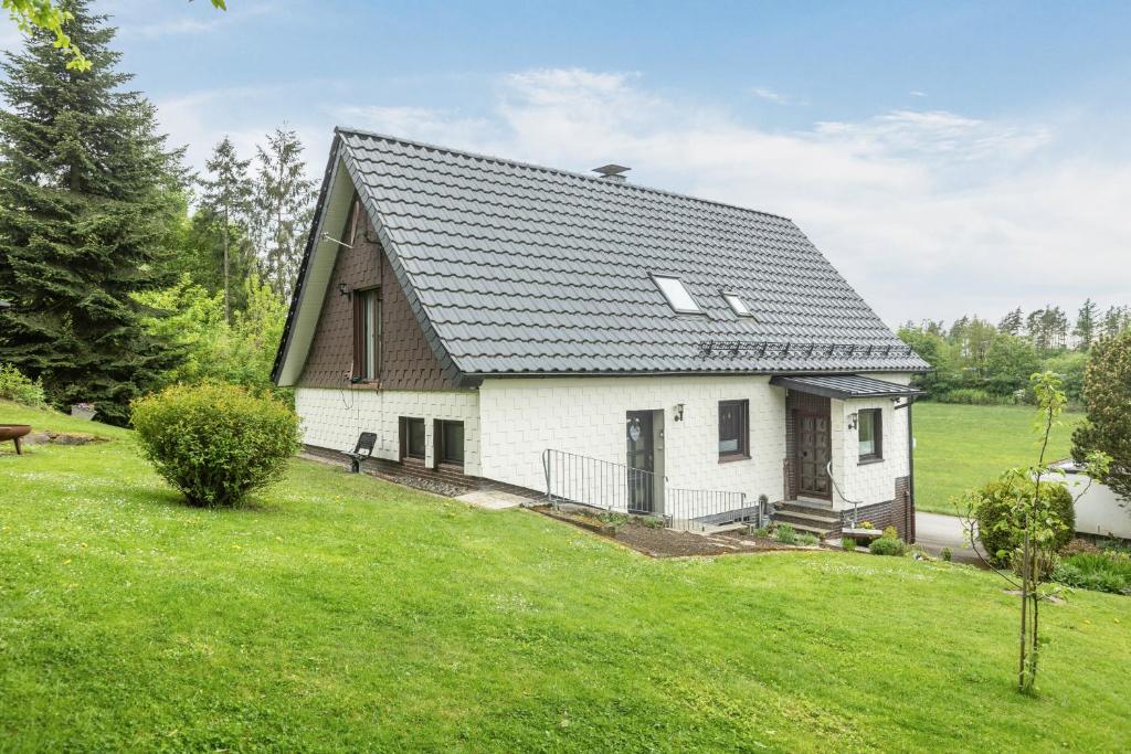 a white house with a black roof at Ferienwohnung Sunnenviul in Lennestadt
