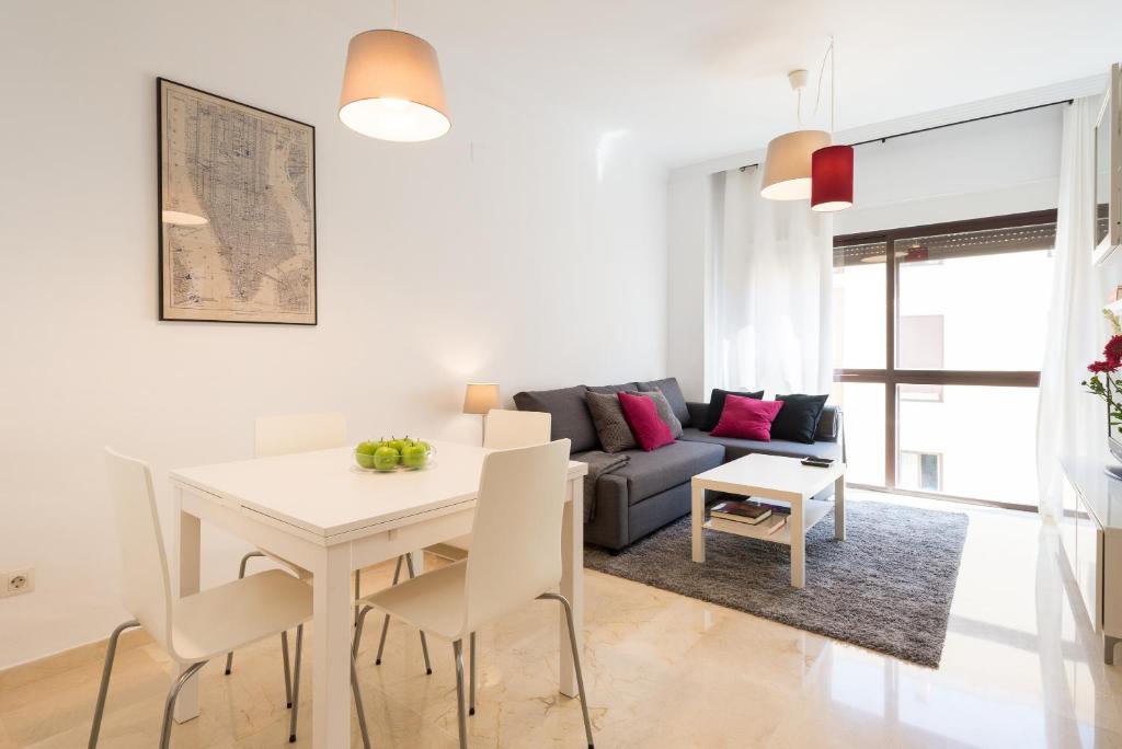 - un salon blanc avec une table et un canapé dans l'établissement Colón12 Urban Apartment, à Malaga