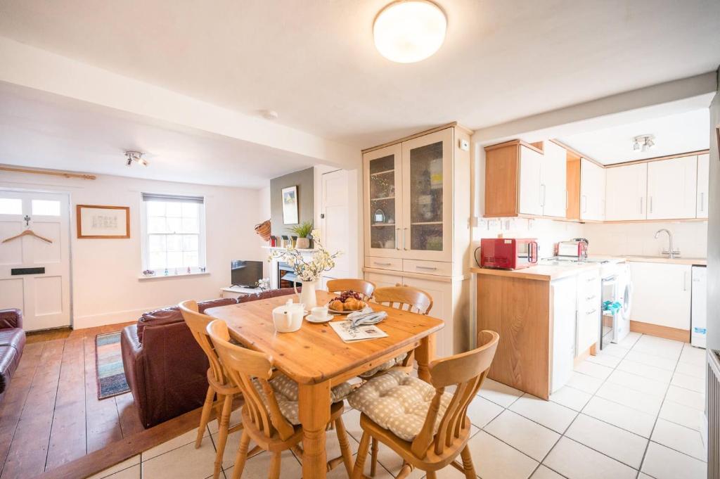 a kitchen and dining room with a wooden table and chairs at Stuckie Ben, Southwold in Southwold