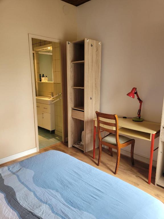a bedroom with a desk and a chair and a table at La Petite Pierre d'Octave Nr 1 in Saint Laurent Nouan