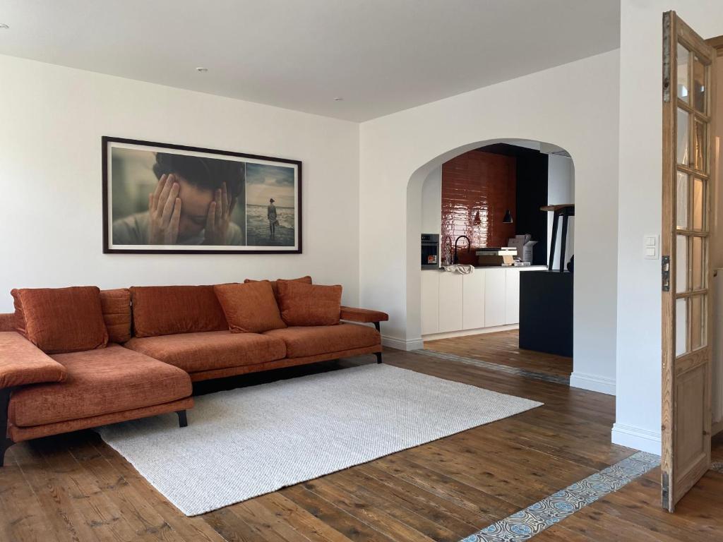 a living room with a brown couch in a room at Studio Mad Grace in Diksmuide