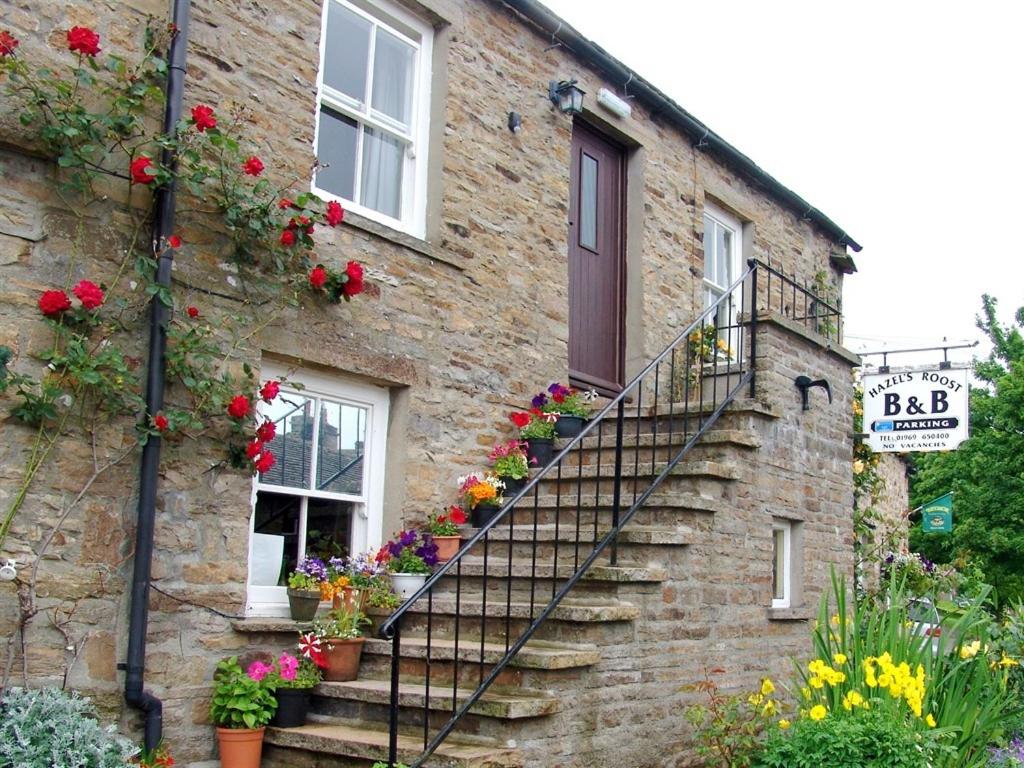 a brick building with flower boxes on the stairs at Hazels Roost in Bainbridge