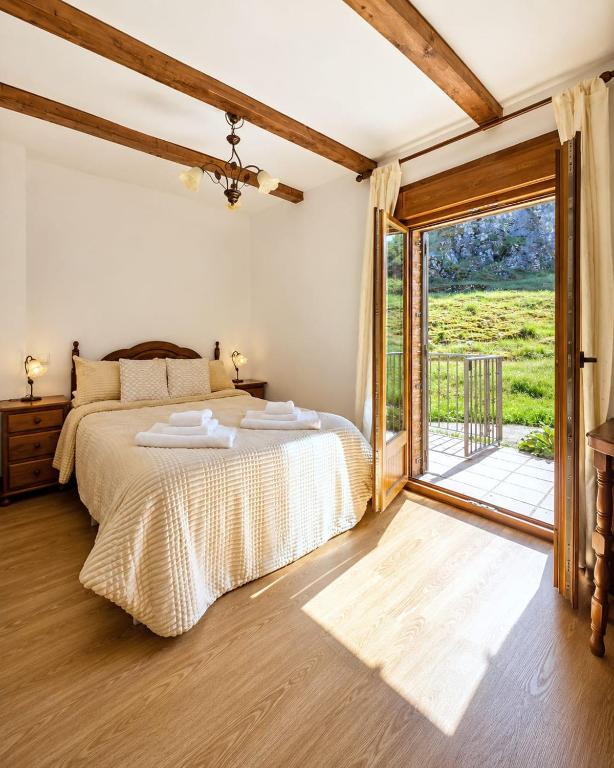 a bedroom with a bed and a sliding glass door at Casa Rural Raíces del Alto Tajo in Armallones