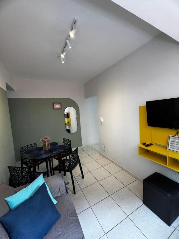 a living room with a table and a tv at Aconchegante Apartamento in Lavras