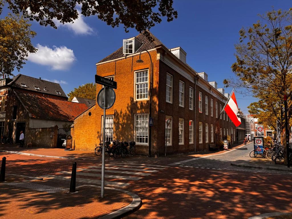 a building with a red flag in front of a street at Stadsklooster Dordt Hotel&Hostel in Dordrecht