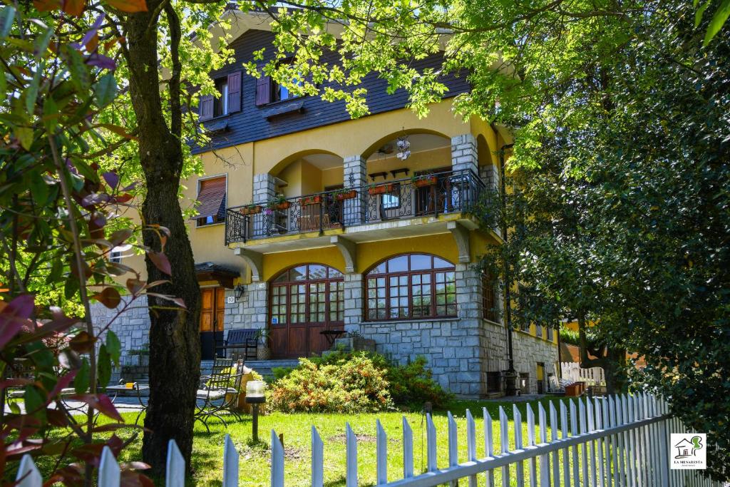 a yellow house with a fence in front of it at Appartamenti La Menaresta quiet & relax near Bellagio in Magreglio