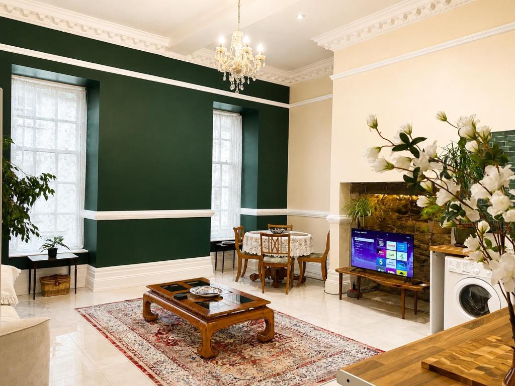 a living room with a green wall at The Fig Tree in Brecon