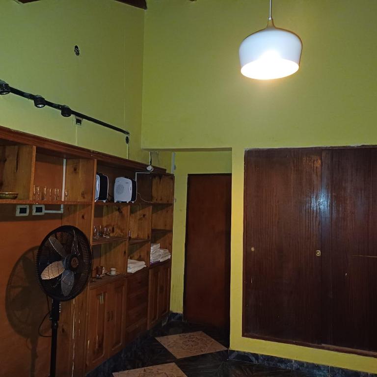a room with a fan and a room with green walls at Génesis in Merlo