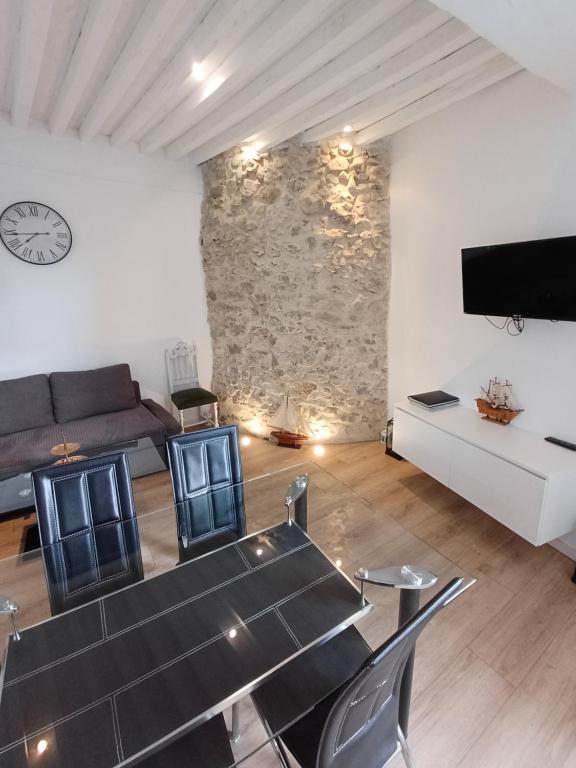 a living room with a stone wall and a table and chairs at Au Thiernois in Thiers