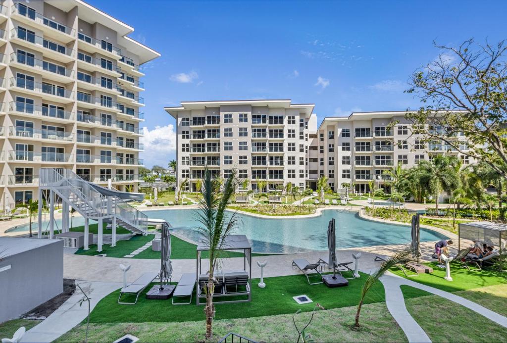 an image of a swimming pool with two apartment buildings at Olas del Mar by Playa Caracol Resorts in Palmira