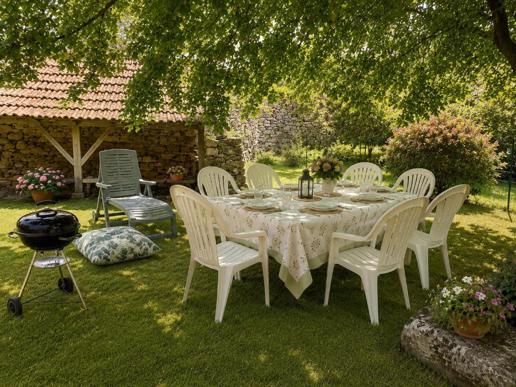 a white table and chairs in a yard at La Parenthèse du Lot in Gramat