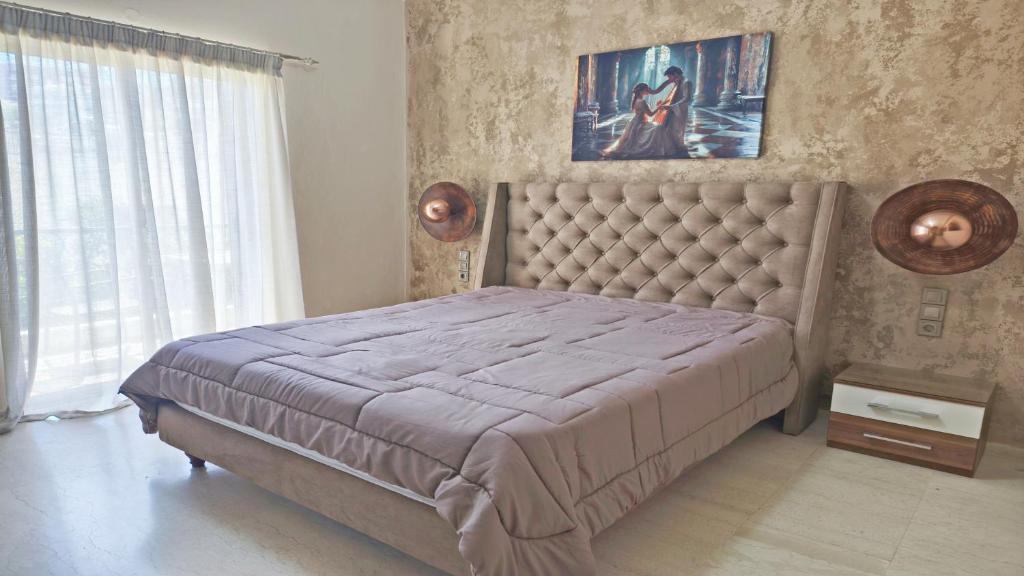 a bedroom with a large bed with a tufted headboard at Villa Maria in Parga