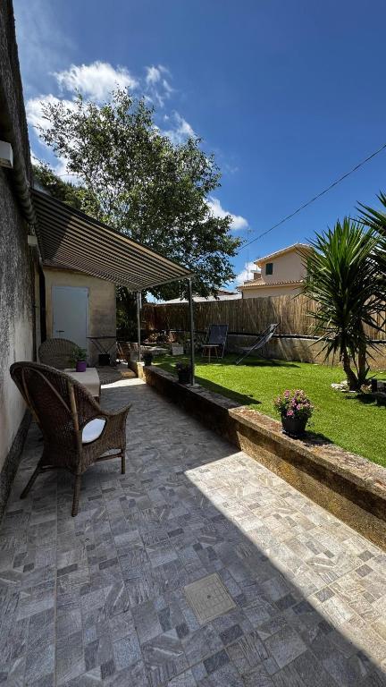 a patio with a bench and a table in a yard at A'MA CASA in Modica