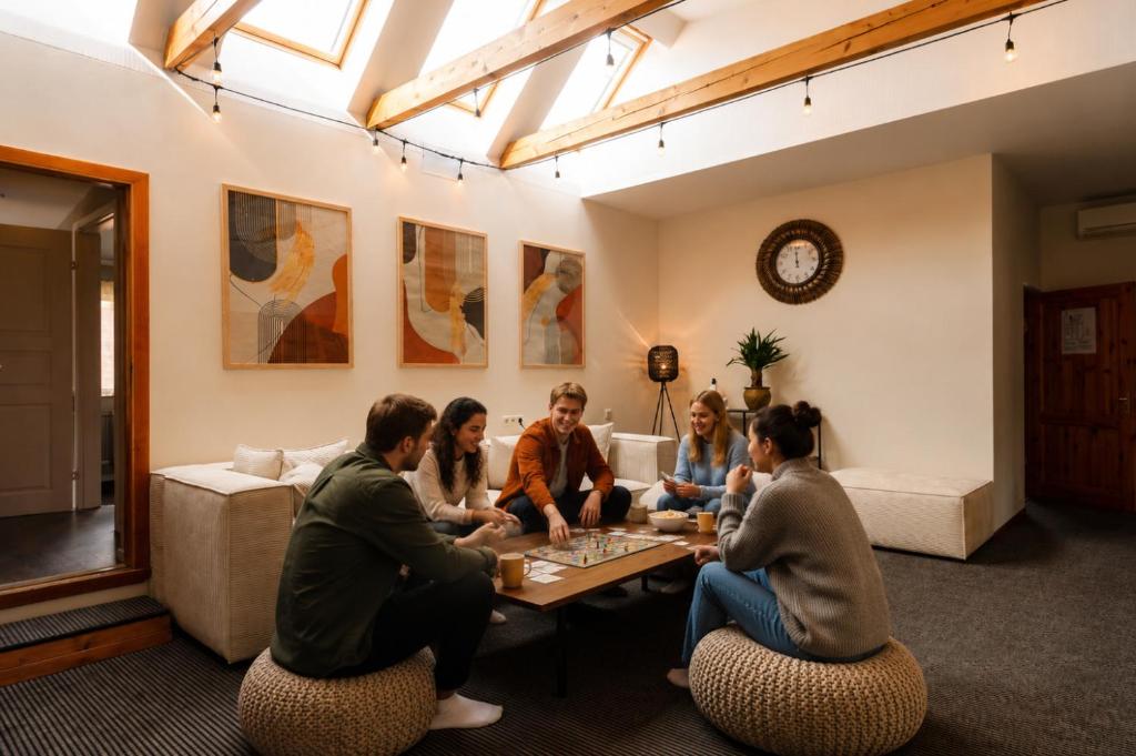 a group of people sitting around a table in a living room at Hang The Hat House in Valmiera
