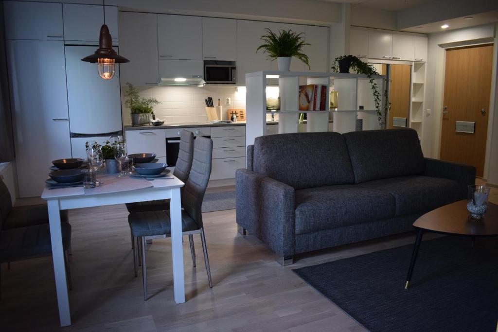 ein Wohnzimmer mit einem Sofa und einem Tisch in der Unterkunft DP Apartments Vaasa in Vaasa