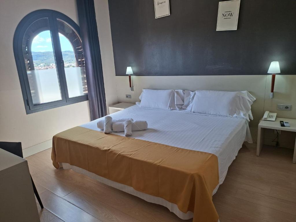 a bedroom with a large bed with towels on it at Hotel El Castell in Sant Boi del Llobregat