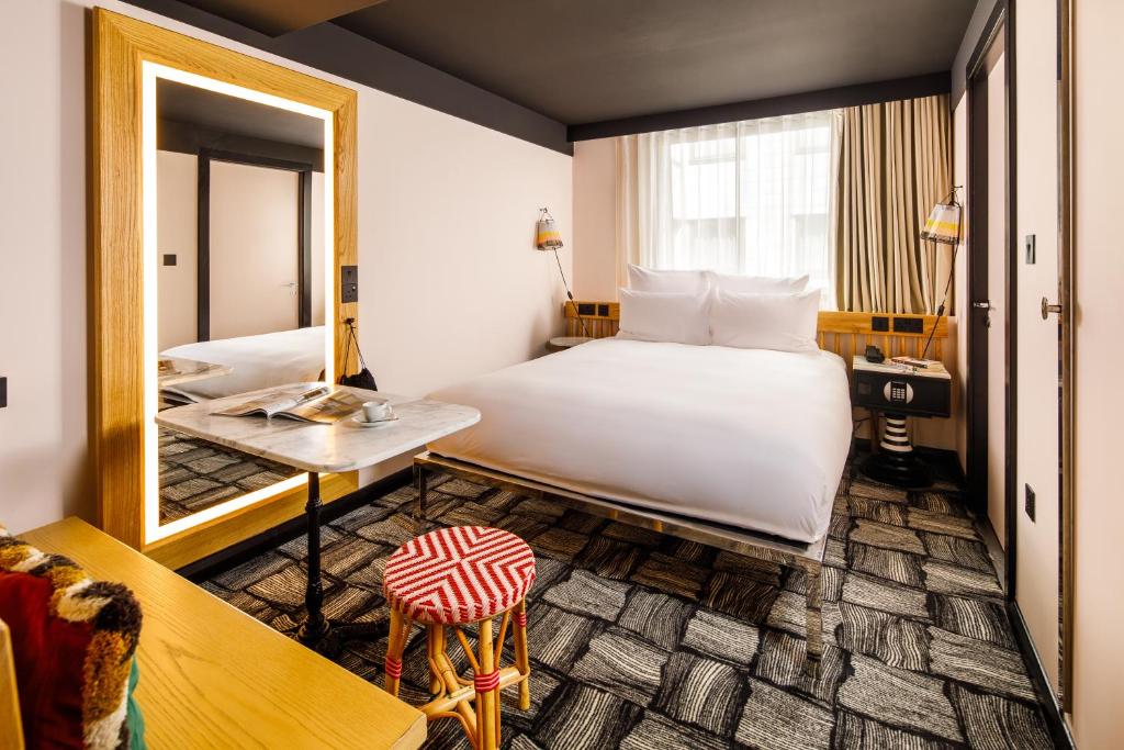 a hotel room with a bed and a mirror at ARK Shoreditch in London
