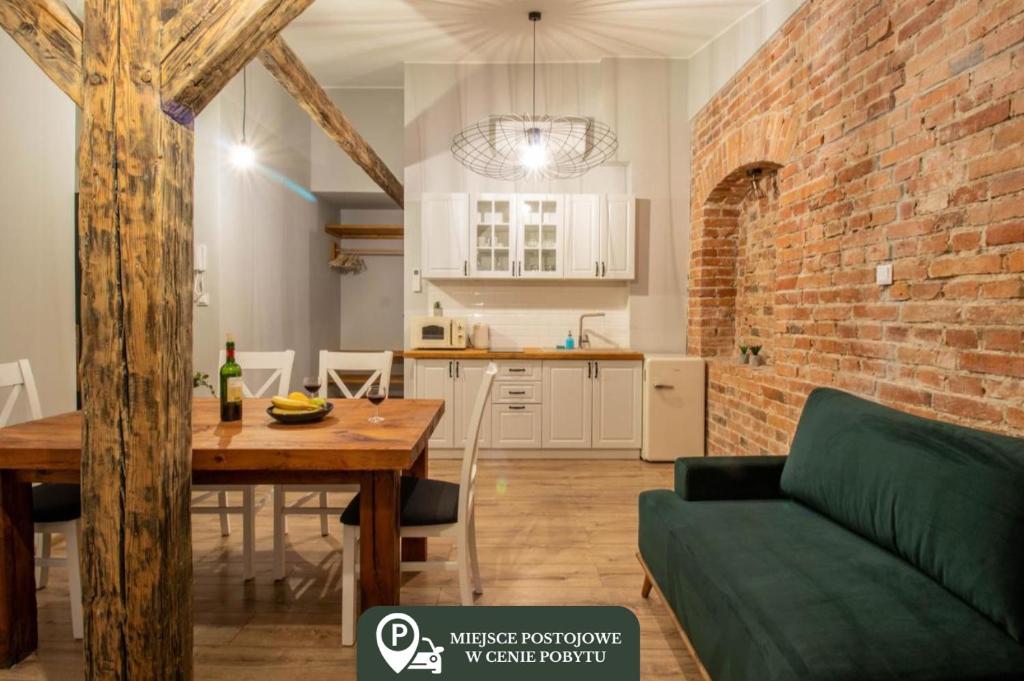a living room with a dining room table and a brick wall at Apartament Starówka 10 (Miodova) in Toruń