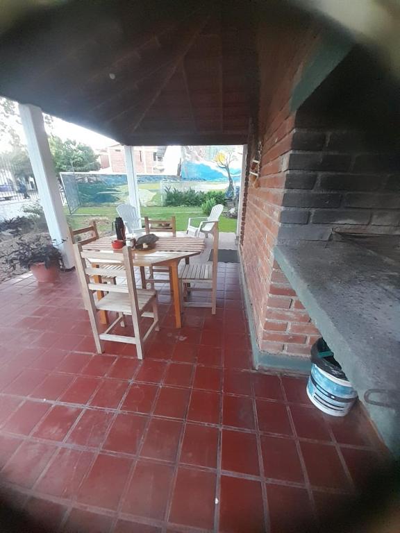 a patio with a table and chairs and a brick wall at tabaquillo in Villa Cura Brochero